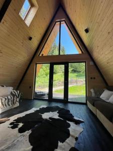Zimmer im Dachgeschoss mit einem großen Fenster und einem Bett in der Unterkunft Macko’s cabin in Băile Tuşnad