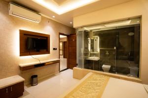 a bathroom with a shower and a tv and a toilet at Hotel RR 62 in Jaipur