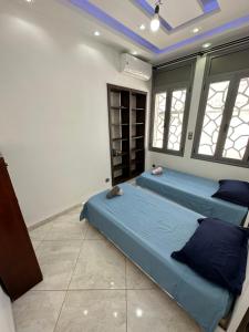 2 camas en una habitación con ventanas en maison luxe à HYDRA F6, en Argel