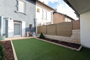 a backyard with a fence and a green lawn at Le Graphite in Auboué