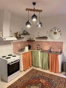 kuchnia z kuchenką, zlewem i dywanem w obiekcie MY HOME w mieście Áno Lekhónia