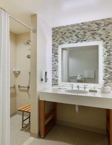 ein Bad mit einem Waschbecken und einem Spiegel in der Unterkunft The Westin Denver International Airport in Denver