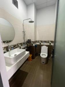 een badkamer met een wastafel, een toilet en een spiegel bij Nam Anh Hotel in Bao Loc