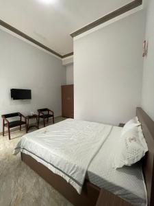 een slaapkamer met een groot bed en een tafel bij Nam Anh Hotel in Bao Loc