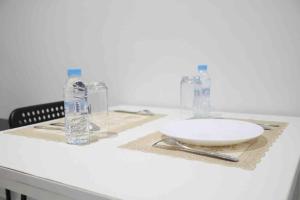 a table with a white plate and two bottles of water at Gauthier studio in Casablanca