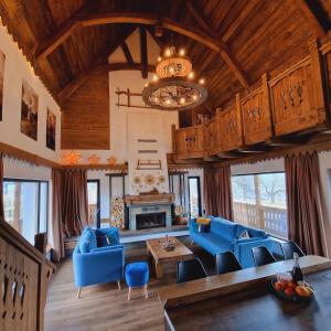 a large living room with blue furniture and a chandelier at Plai din Bran in Bran