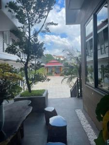 un patio con taburetes y un árbol y un edificio en Nam Anh Hotel, en Bao Loc