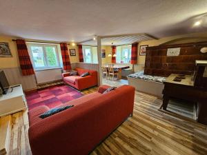 a living room with a red couch and a piano at Wutachschlucht - spacious apartment in renovated farmhouse in Bonndorf im Schwarzwald