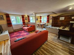 - un salon avec un canapé rouge et un piano dans l'établissement Wutachschlucht - spacious apartment in renovated farmhouse, à Bonndorf im Schwarzwald
