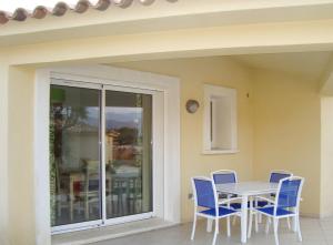 een veranda met een tafel en stoelen op een patio bij Résidence Odalys San Martinu in Sainte-Lucie de Porto-Vecchio