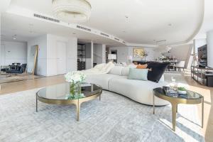 uma sala de estar com um sofá branco e duas mesas em Frank Porter - Marina Terrace Tower em Dubai