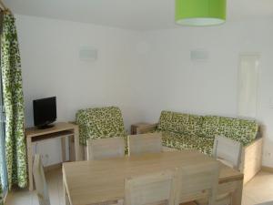 een woonkamer met een bank en een tafel en stoelen bij Résidence Odalys San Martinu in Sainte-Lucie de Porto-Vecchio