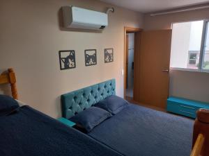 舊巴拉的住宿－Pé na areia - próximo ao Beto Carreiro，一间卧室设有蓝色的床和窗户。