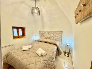a bedroom with a bed with two towels on it at Trulli Fenice Alberobello in Alberobello
