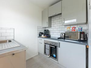 a kitchen with white cabinets and a counter top at Tettenhall Lodge in Wolverhampton