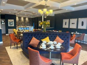 a dining room with a blue couch and chairs at The Fig Tree Hotel in Shanklin