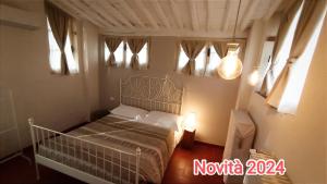 a bedroom with a bed in a room with windows at Dimora San Lazzaro B&B in Lucca