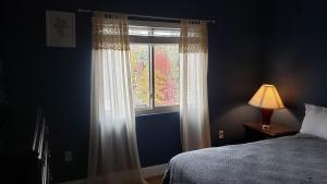 a bedroom with a window with a bed and a lamp at Gatlinburg Chateau Condo 307 in Gatlinburg