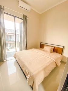 Ce lit se trouve dans un dortoir doté d'une grande fenêtre. dans l'établissement Villa Kamar Tamu Sentul, à Pasirkapa