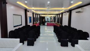 a row of black chairs in a room with a table at Hotel Om in Betūl