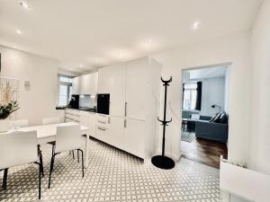 cocina y comedor con armarios blancos y mesa en Business Apartment ZIMMERzuVERMIETEN in Solothurn, en Solothurn