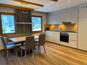 a kitchen with a dining room table and chairs at Chasa Ravaischa in Samnaun