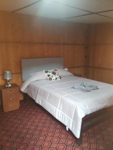um quarto com uma cama branca e uma mesa de cabeceira em the wooden house choquequirao em Cachora