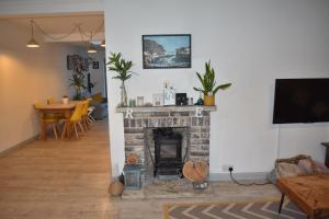 a living room with a brick fireplace and a table at Goodwood Events House with Garden & Parking - Chichester Holiday Properties in Chichester