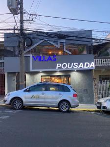 une voiture en argent garée devant un magasin dans l'établissement Pousada Villas, à Sorocaba