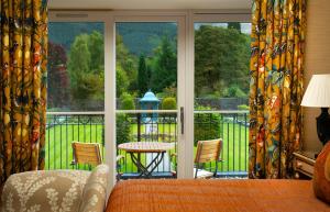 um quarto com uma cama e uma varanda com vista em Inverlochy Castle Hotel em Fort William