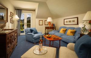 a living room with blue chairs and a couch at Inverlochy Castle Hotel in Fort William
