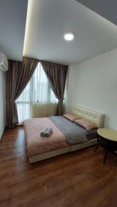a bedroom with a bed and a table and a window at Viva City Magamall Jazz 1 53 in Kuching