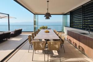 an open kitchen and dining room with a long table and chairs at Villa Mirabel in Mimice