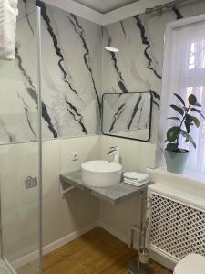 a white bathroom with a sink and a mirror at Family Guest House & Hostel in Bishkek