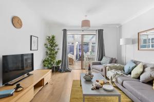 a living room with a couch and a tv at Chandlers Walk modern comfy family home in Exeter in Exeter