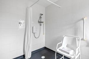 a white shower with a white chair in a bathroom at Lytton Tree Lodge Reydon in Reydon