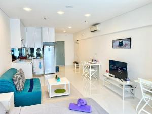 a living room with a blue couch and a kitchen at Summer suites victory house in Kuala Lumpur
