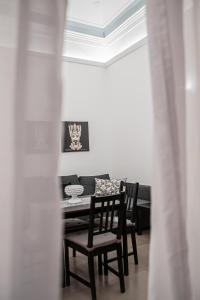 a dining room with a table and chairs and a ceiling at Ruggero Settimo - Holiday Houses in Catania