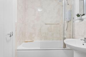 een badkamer met een douche, een bad en een wastafel bij Chandlers Walk modern comfy family home in Exeter in Exeter