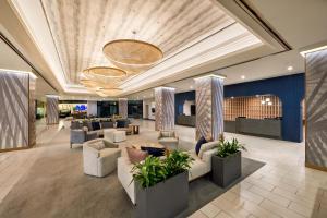 a lobby with couches and plants in a building at Hotel Fera Anaheim, a DoubleTree by Hilton Hotel in Anaheim