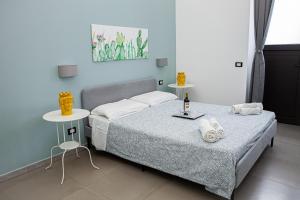 a bedroom with a bed and two tables with towels at Ruggero Settimo - Holiday Houses in Catania