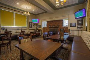 a restaurant with tables and chairs and a fireplace at Fairway Inn in Manchester