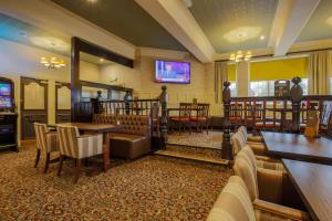 a restaurant with tables and chairs and a flat screen tv at Fairway Inn in Manchester +19 photos