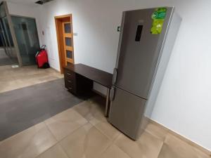Cette chambre comprend un grand réfrigérateur et une valise rouge. dans l'établissement Fantastic ZG - S4 Pokój 204, à Zielona Góra