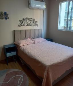 舊巴拉的住宿－Pé na areia - próximo ao Beto Carreiro，一间卧室配有一张带粉色床单的床和一扇窗户。