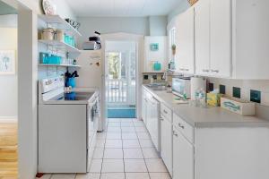 a kitchen with white cabinets and white appliances at Vintage Venice Duplex - A in Venice