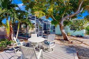 a table and chairs on a deck with a tree at Vintage Venice Duplex - A in Venice
