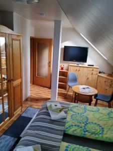 a bedroom with a bed and a table and a tv at Ferienwohnung Anna in Wernigerode