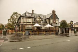 a large building with white umbrellas in front of it at Fairway Inn in Manchester