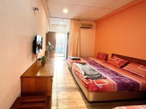 a hotel room with two beds and a television at Heng Ann Guest House in Melaka